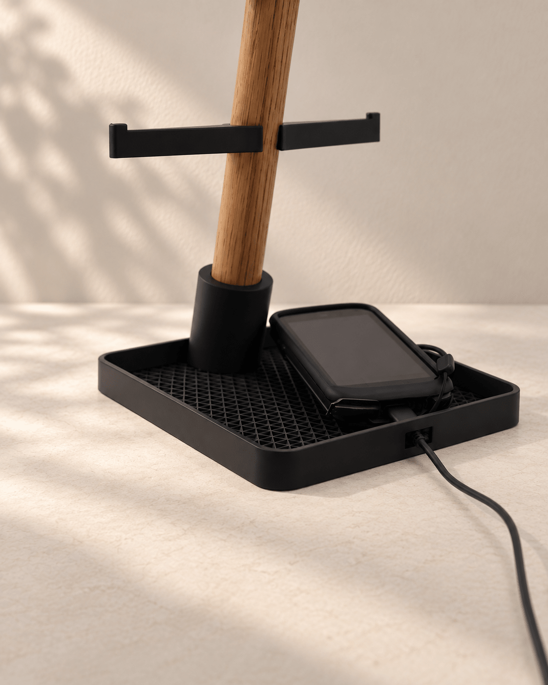 Desk Organizer Tray base close-up – storage tray holding a bike computer with the charging cable routed through the side slot