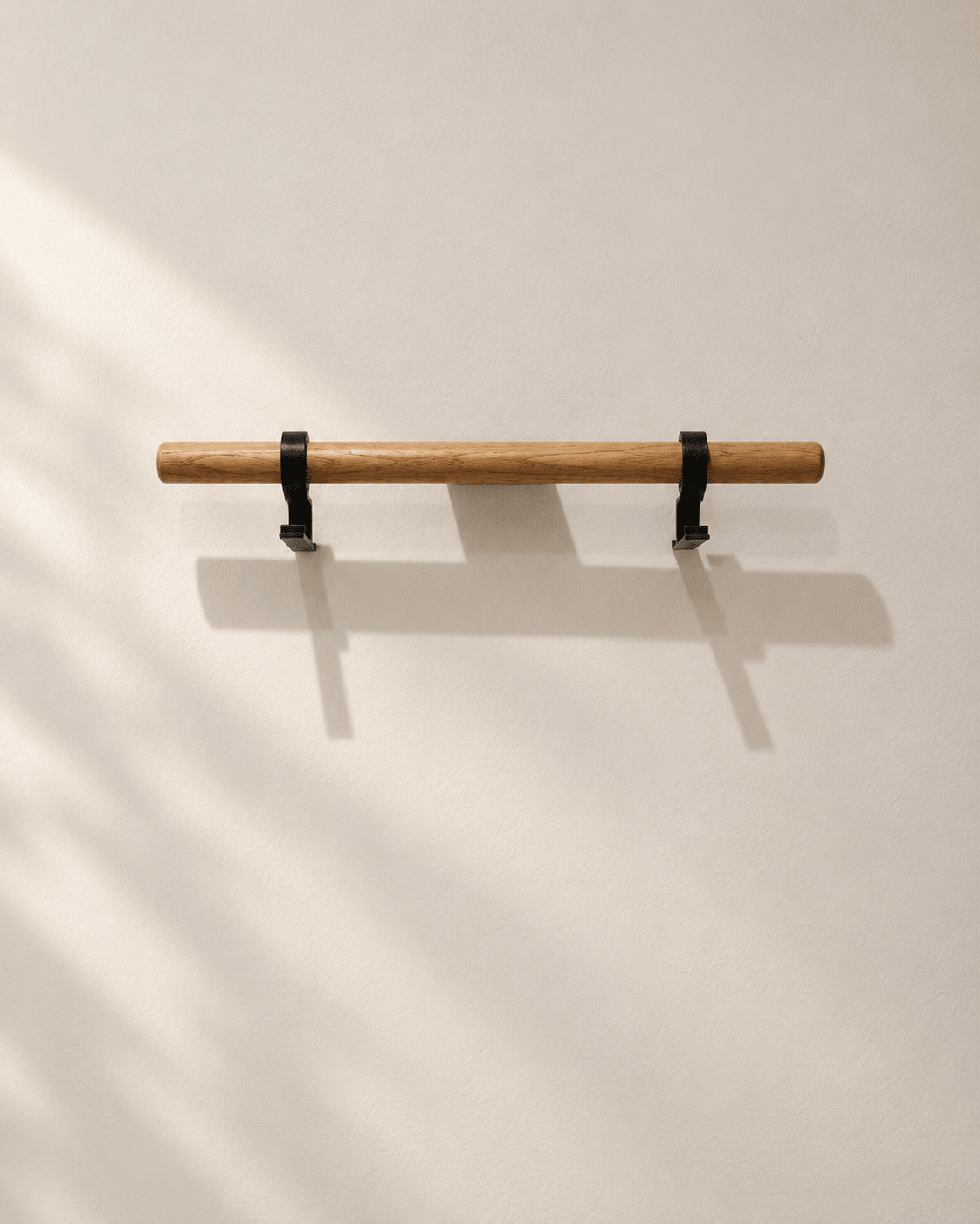 Empty lacquered oak Bar with two black 3D-printed hooks mounted on a wall